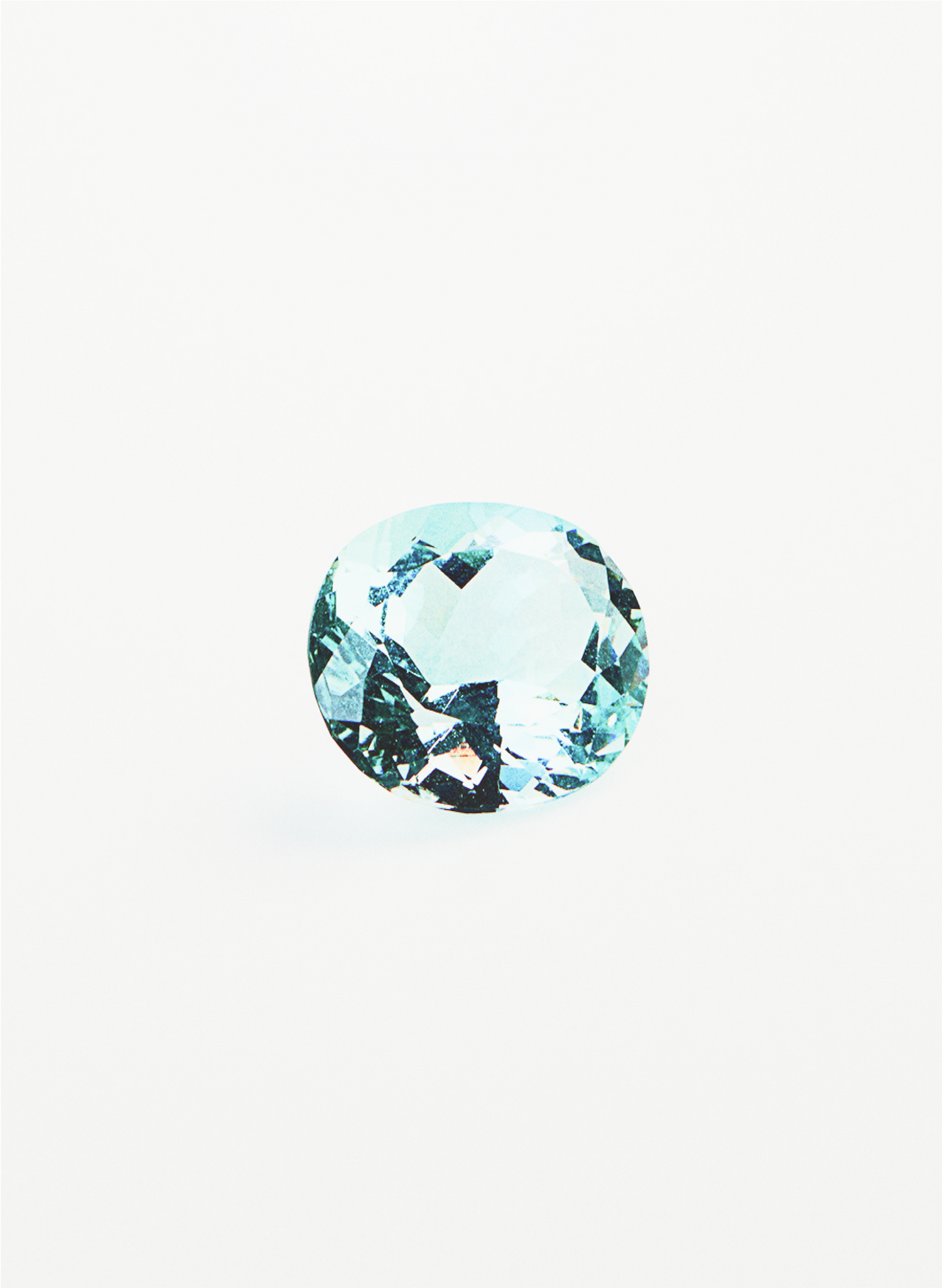 Studio close-up of a faceted oval-cut aquamarine gemstone with pale blue clarity and reflective facets, displayed against a stark white background